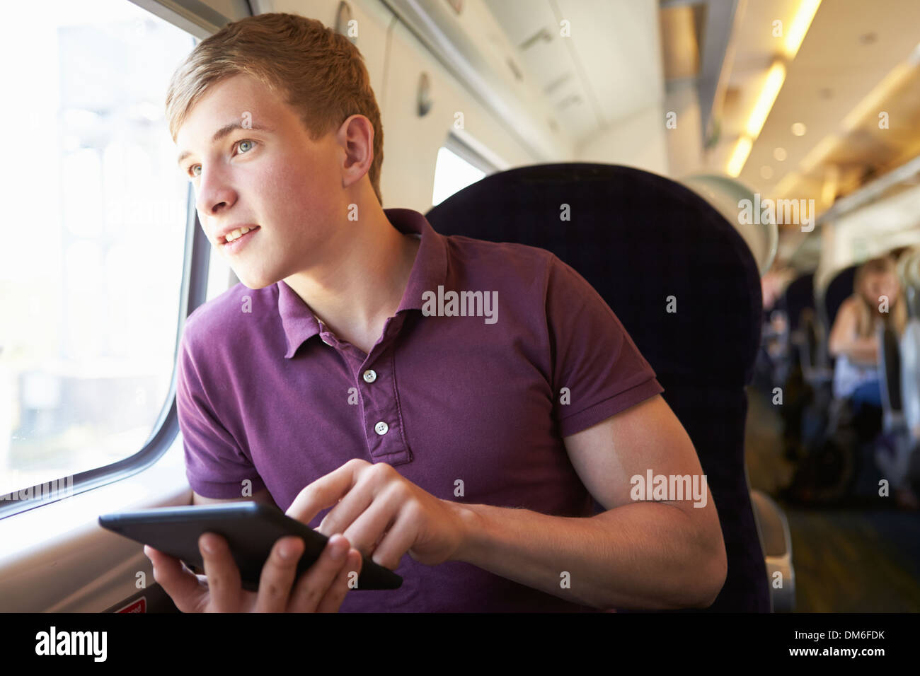 Junger Mann E Lesebuch auf Zugfahrt Stockfoto