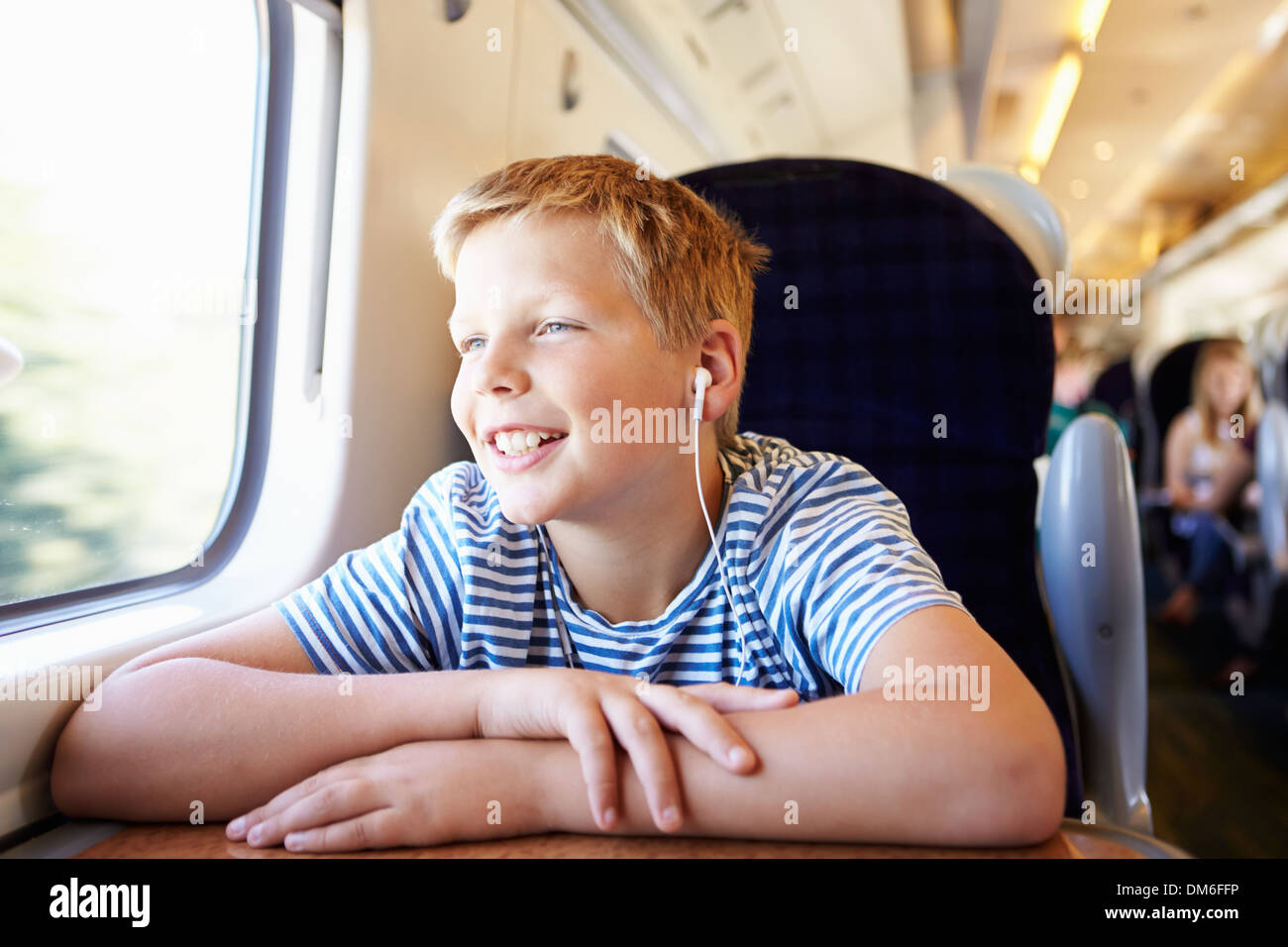 Junge Musik hören auf Zugfahrt Stockfoto