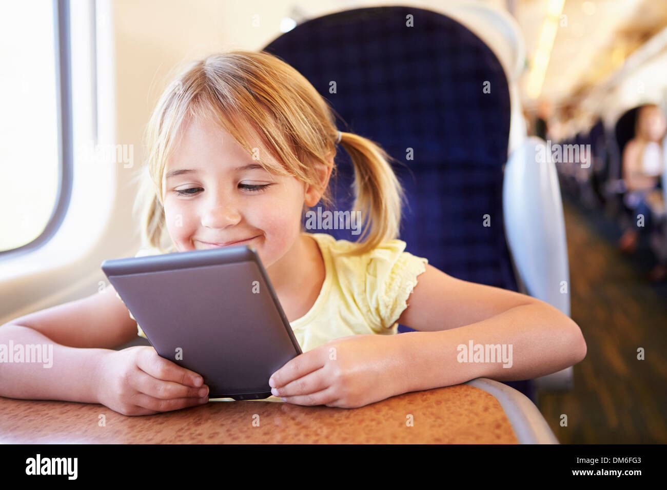 Mädchen lesen E-Book auf Zug Stockfoto