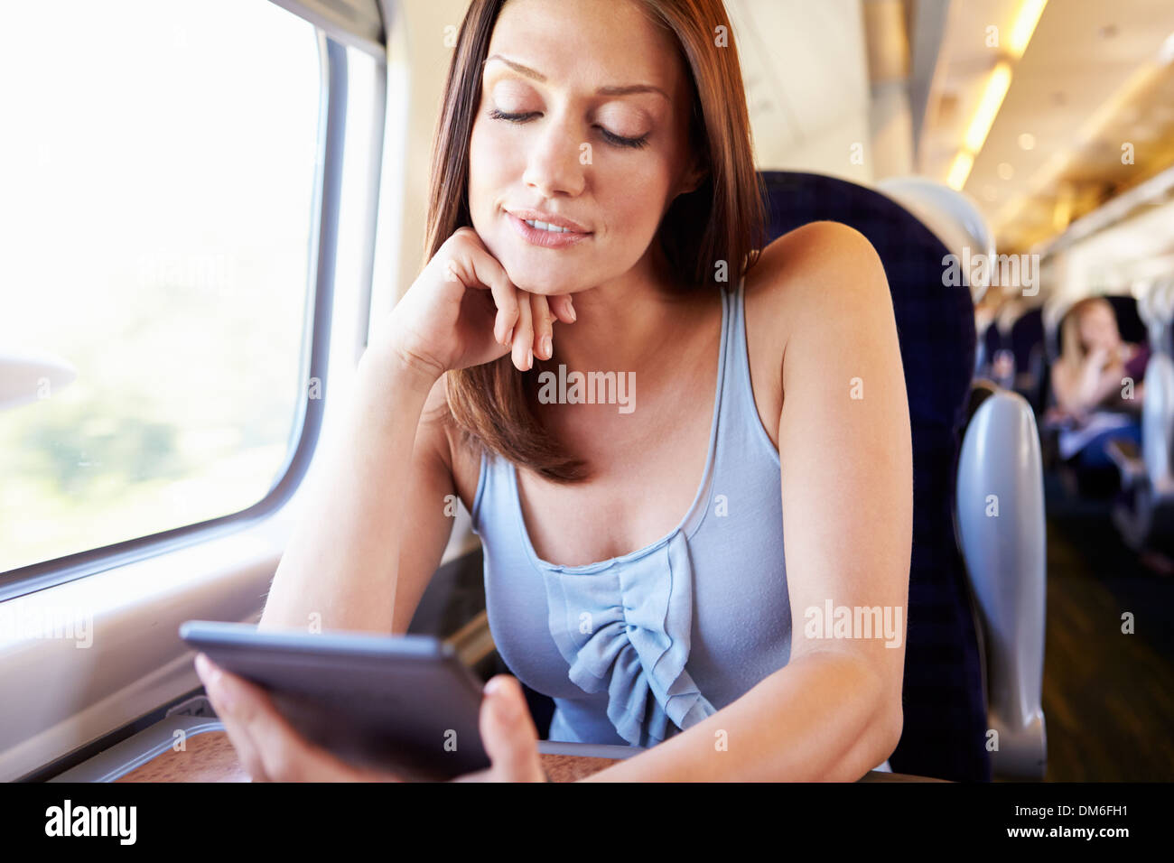 Frau liest E-Book auf Zug Stockfoto
