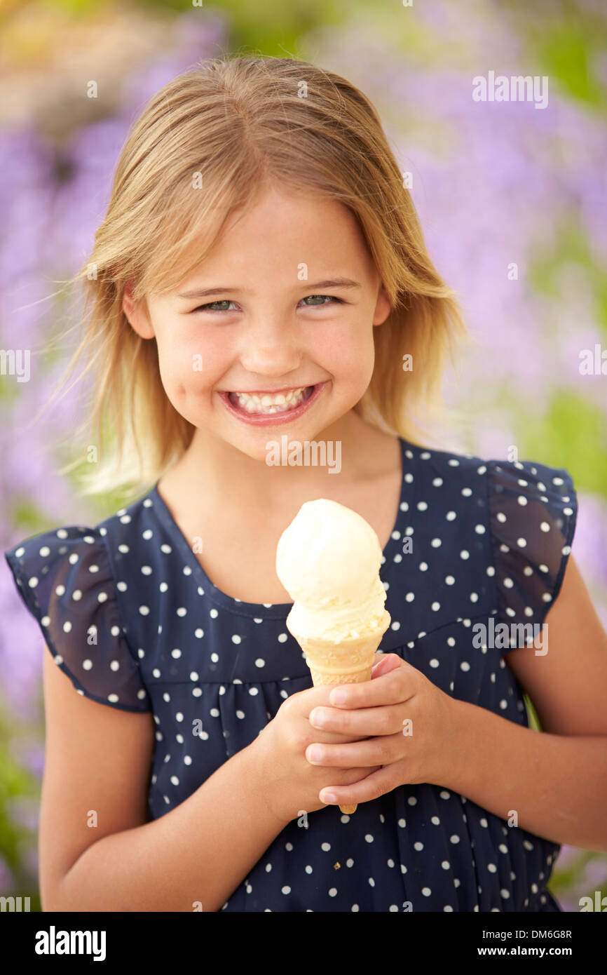 Junges Mädchen draußen Eis essen Stockfoto