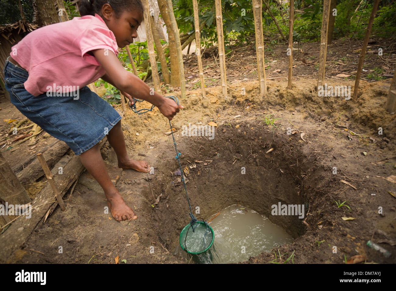 Eine Mädchen zieht das Wasser aus einem verschmutzten gut in Fenerive Est Bezirk, Madagaskar. Stockfoto