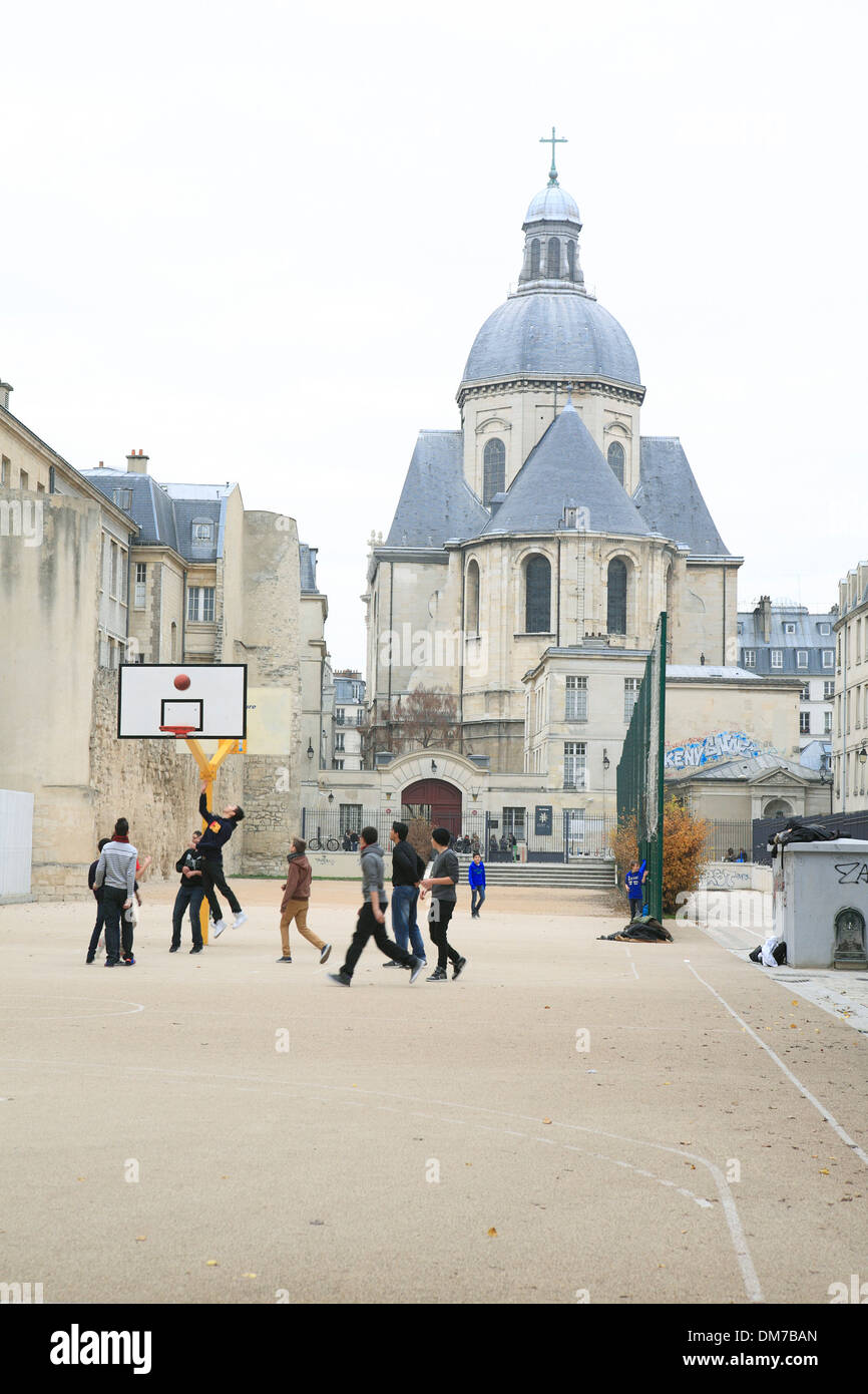 Teenager spielen Basketball am Sportplatz infront des Lycée Charlemagne Schule. Paris, Frankreich, Europa Stockfoto