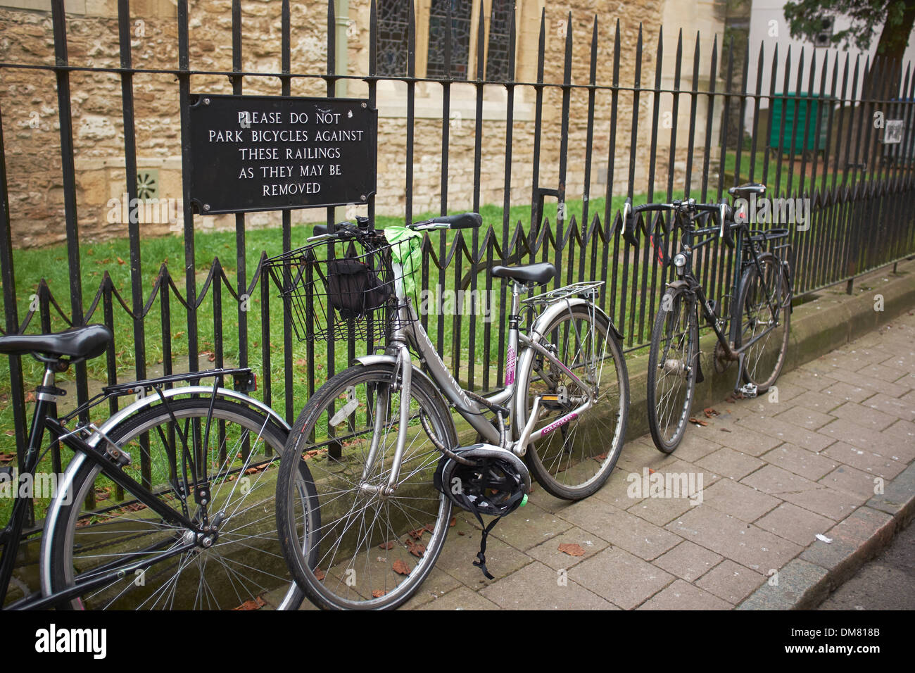 Fahrräder im Stadtzentrum von Oxford angekettet an Geländer mit einem Nein Fahrräder-Schild Stockfoto
