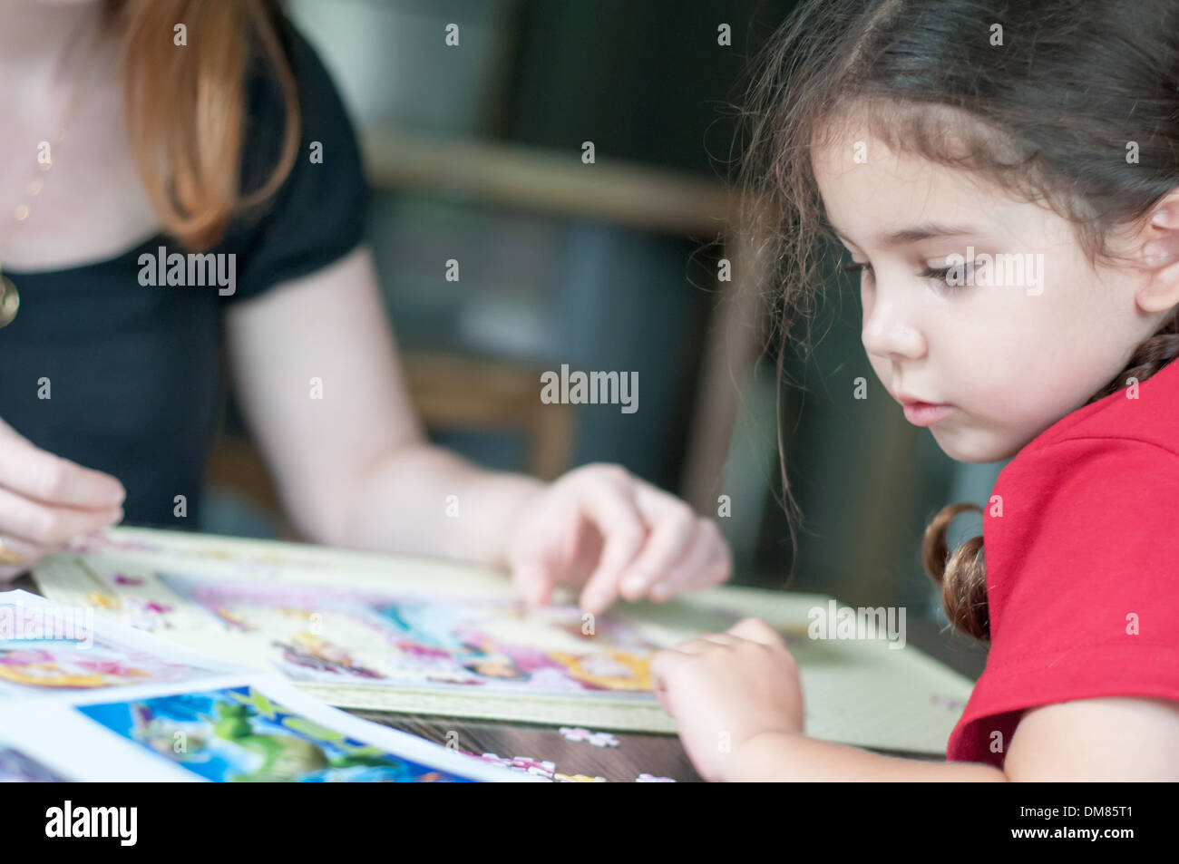 Erwachsene und Kinder spielen puzzle Stockfoto
