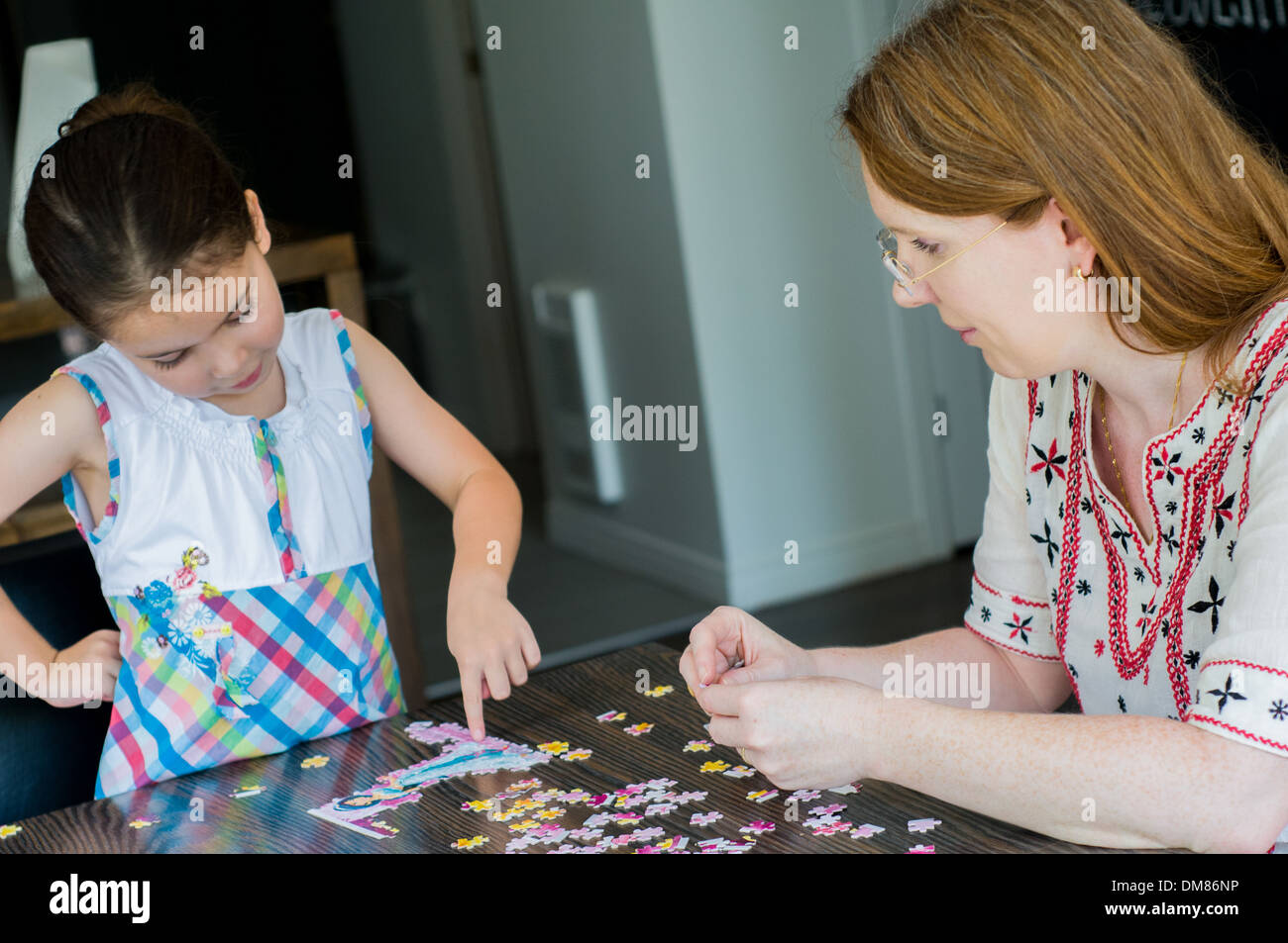 Erwachsene und Kinder spielen puzzle Stockfoto