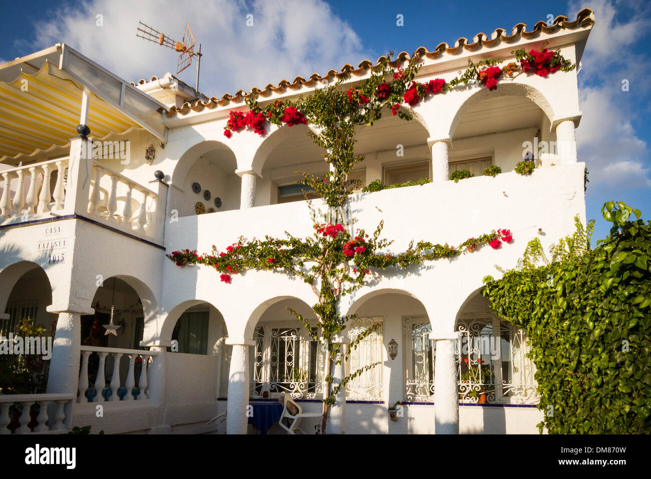 Rote Blumen schmücken die Front eines Hauses in Südspanien Stockfoto