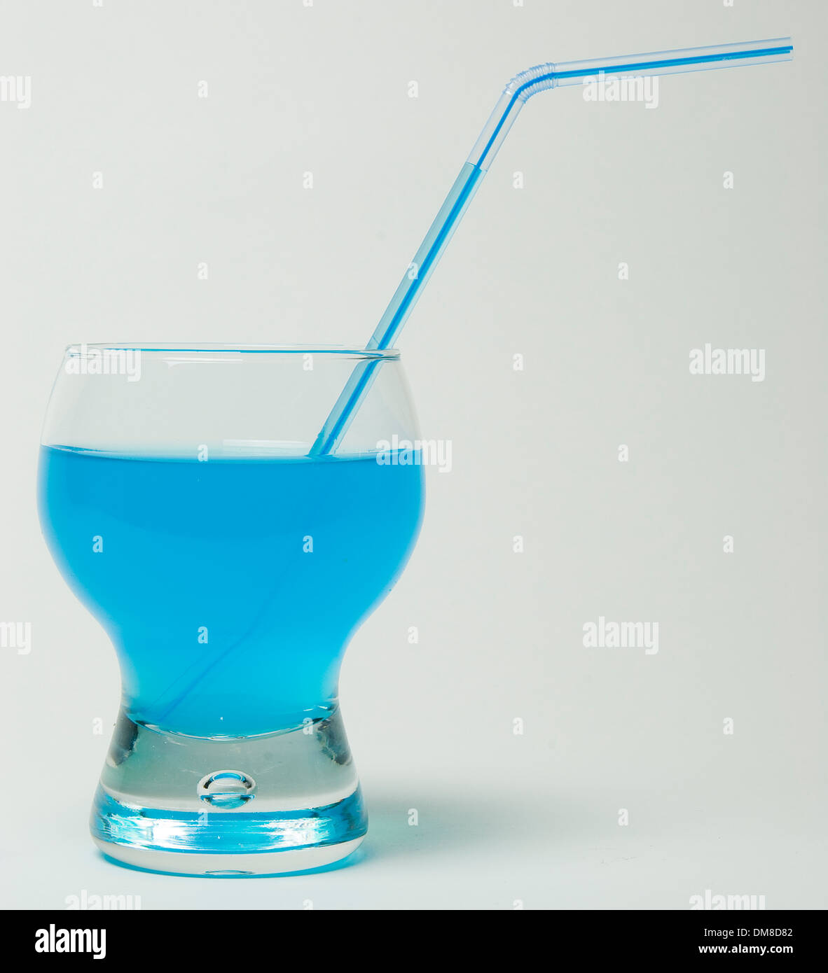 Glas mit Stroh und blaue Flüssigkeit darin auf weißem Hintergrund Stockfoto