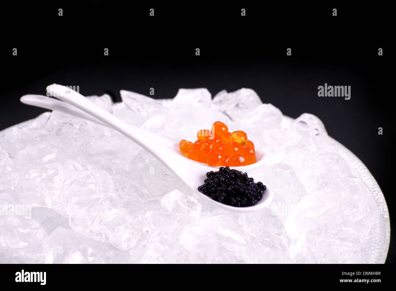 Porzellanlöffel voller rot und Stör Kaviar schwarz, Nahaufnahme Stockfoto