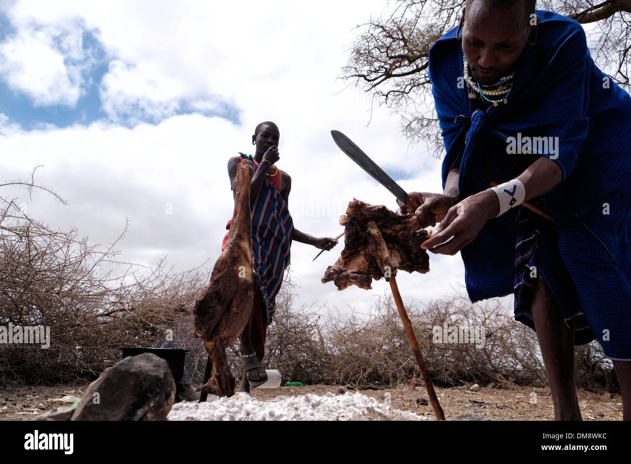 Maasai Männer Essen vom Grill, eine Ziege, die in einem traditionellen  Schlachten Methode, bei der die Ziege zum Tod durch umklammern Hände über  seine Nase und Mund, um nicht den Verlust von