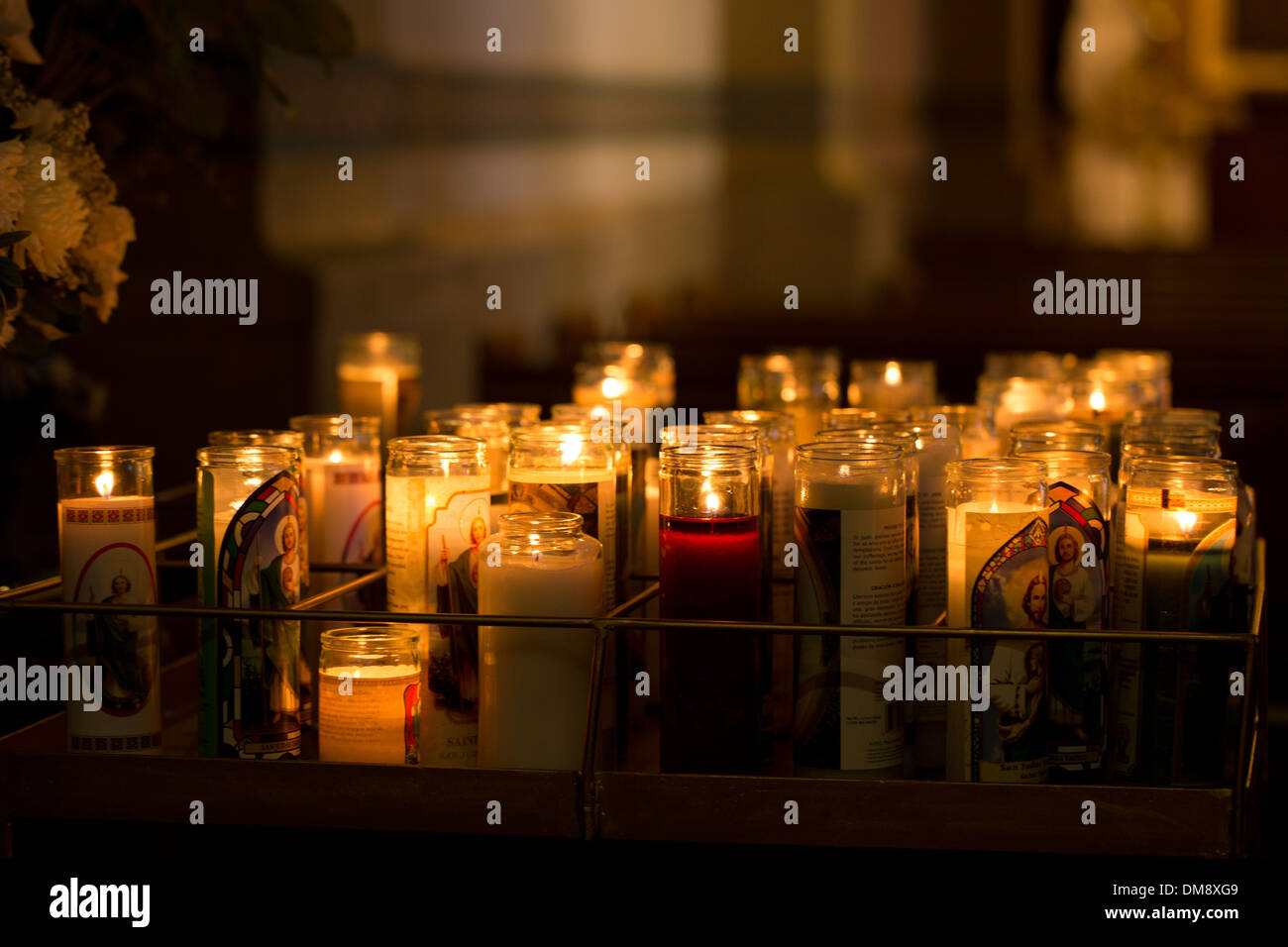 Votiv-Kerzen in einem abgedunkelten Raum Stockfoto