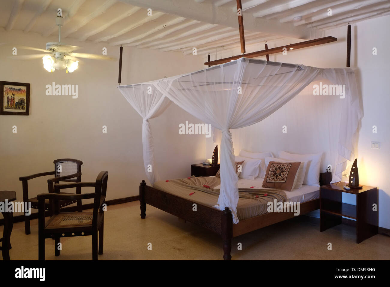 Bett mit Moskitonetz Baldachin in einem Zimmer im Diamonds Mapenzi Beach  Hotel an der Nordostküste der Insel Sansibar, einem halb autonomen Teil von  Tansania, in Ostafrika Stockfotografie - Alamy