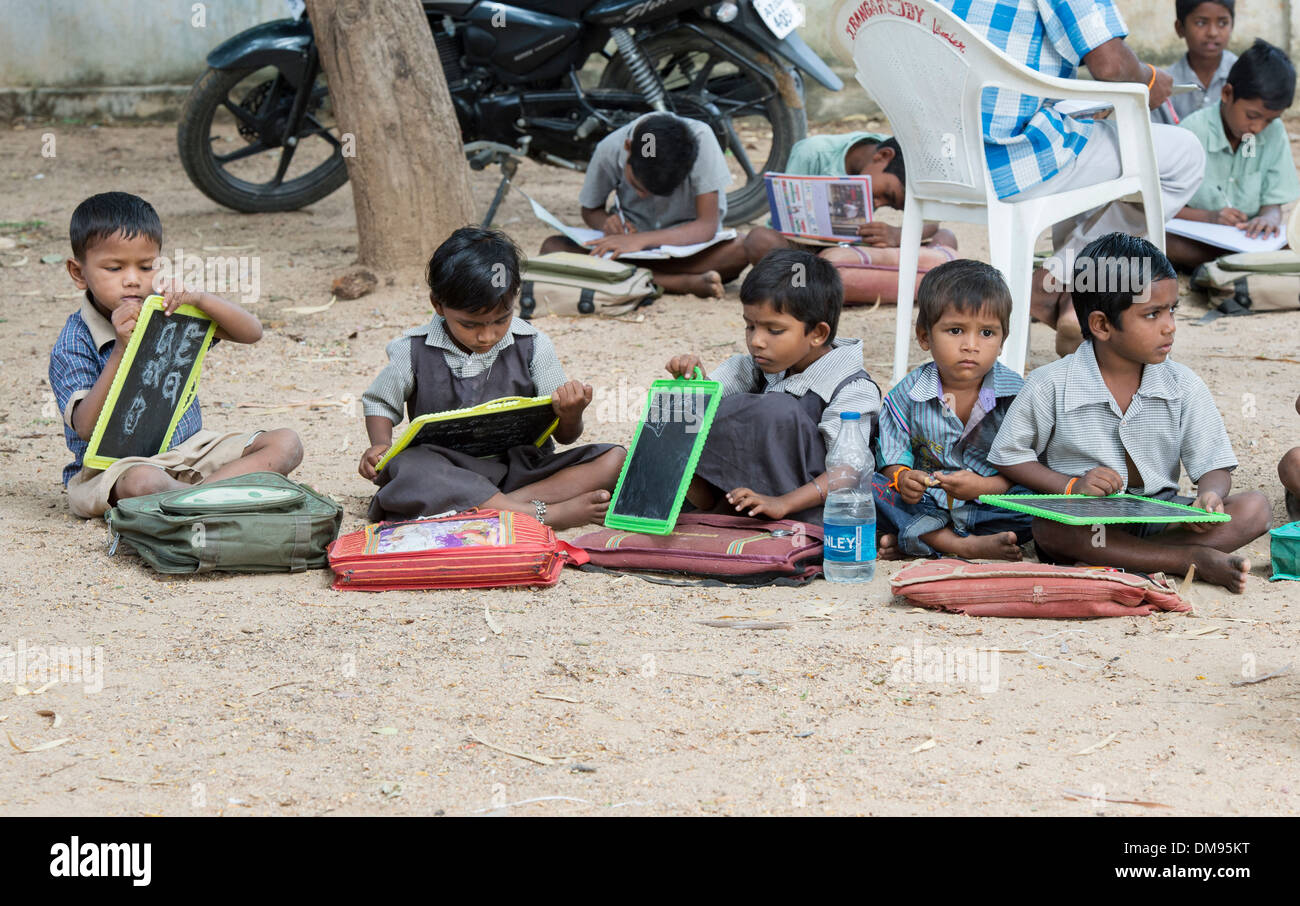 Indische Bauerndorf Schulkinder in einer externen Klasse schreiben auf eine Kreide-Tabletten. Andhra Pradesh, Indien Stockfoto