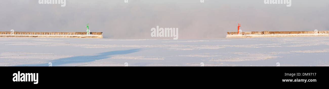 Panoramafoto von Maultier oder Pfeiler mit roten und grünen Leuchtfeuer oder Leuchttürme an nebligen Wetter im Winter. Stockfoto