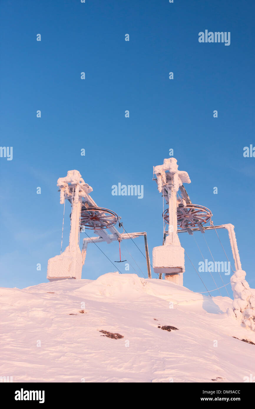 Ski lift Maschinen auf warmen untergehende Sonne am Abend gefroren Stockfoto