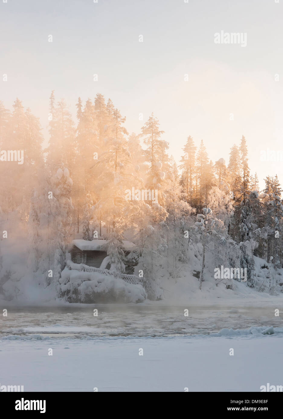 Hütte in der Nähe von Wasser und nebligen Wald im Winter in Lappland, Finnland Stockfoto