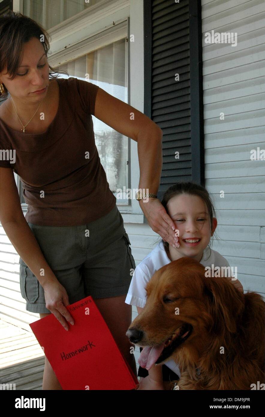 Sep 07, 2005 - Latonia, Kentucky, USA - evakuiert von Jefferson Parish, LA, (in der Nähe von New Orleans), MARGARITA TORRES und ihre sechs Jahre alte Tochter KASSANDRA sind durch ihren Hund Ceaser begrüßt, als sie aus Holly Cross Schule in Latonia zurück zum Haus von Margarita Torres Schwester Madison Pike, wo sie von den Nachwirkungen Verwüstungen durch Hurrikan Katrina Zuflucht gesucht haben. Stockfoto