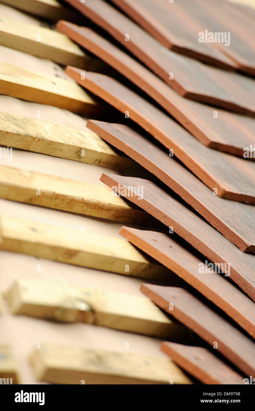 Neue Dachschiefer gehen auf einer traditionellen Scheune Stockfoto