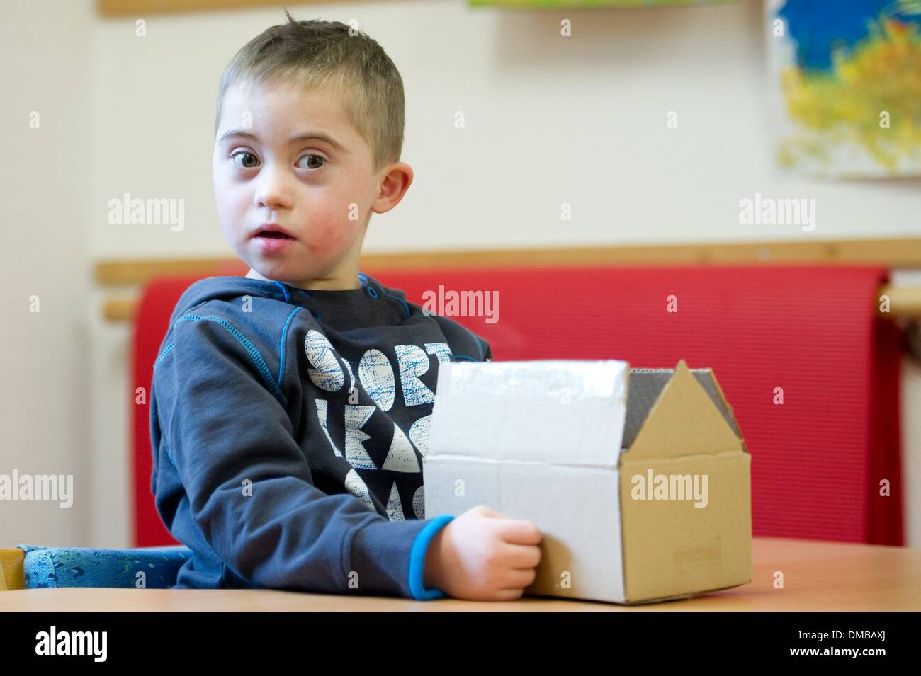 Dresden, Deutschland. 5. Dezember 2013. Fünf-jährige Valentino mit Down Syndrom sitzt während der Ergotherapie in einem Therapieraum im Sociopediatric-Zentrum (SPZ) am Klinikum Dresden-Neustadt in Dresden, Deutschland, 5. Dezember 2013. (Model-Release verfügbar) Foto: Sebastian Kahnert/Dpa/Alamy Live News Stockfoto