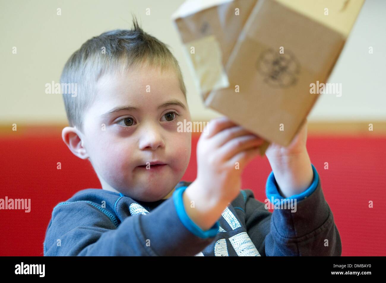 Dresden, Deutschland. 5. Dezember 2013. Fünf-jährige Valentino mit Down Syndrom sitzt während der Ergotherapie in einem Therapieraum im Sociopediatric-Zentrum (SPZ) am Klinikum Dresden-Neustadt in Dresden, Deutschland, 5. Dezember 2013. (Model-Release verfügbar) Foto: Sebastian Kahnert/Dpa/Alamy Live News Stockfoto