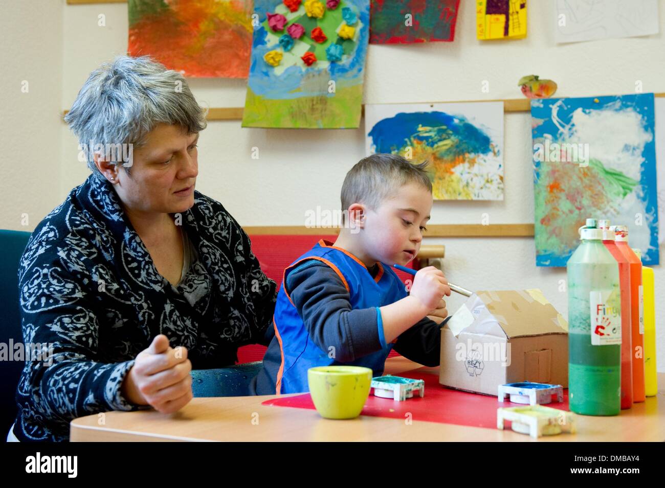 Dresden, Deutschland. 5. Dezember 2013. Fünf-jährige Valentino mit Down Syndrom sitzt mit Ergotherapeut Ines Maennig während der Ergotherapie in einem Therapieraum im Sociopediatric-Zentrum (SPZ) am Klinikum Dresden-Neustadt in Dresden, Deutschland, 5. Dezember 2013. (Model-Release verfügbar) Foto: Sebastian Kahnert/Dpa/Alamy Live News Stockfoto