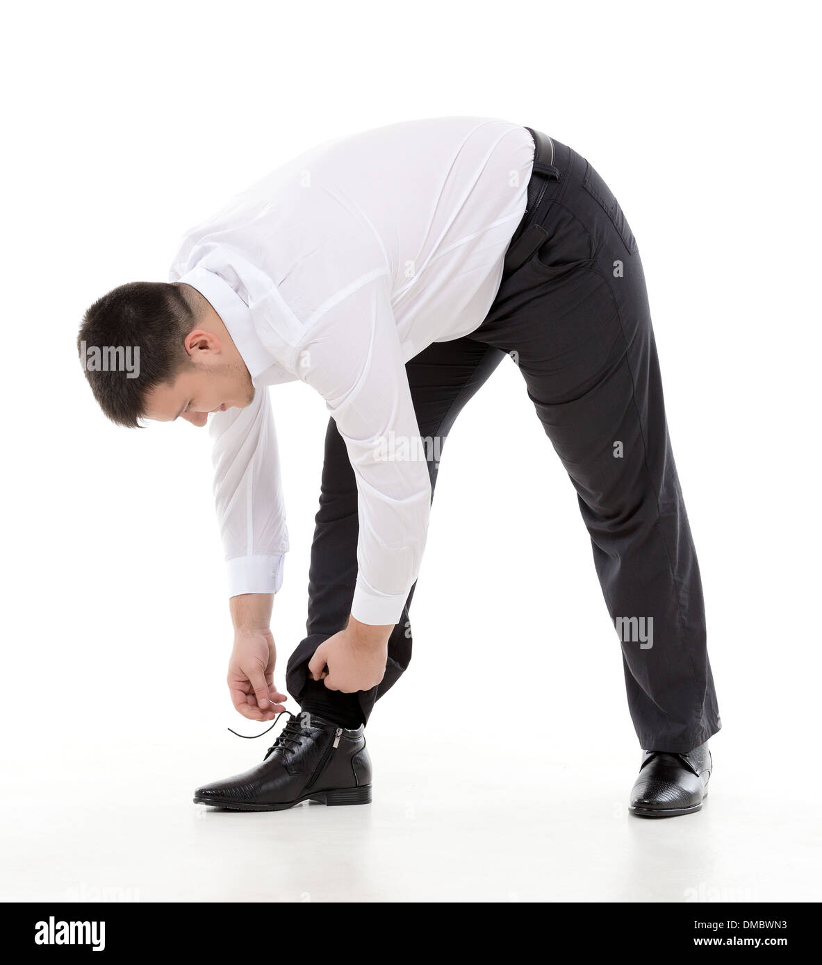 Geschmeidige Geschäftsmann Biegen bis zu tun, seine Schnürsenkel auf seine elegante Lederschuhe Stockfoto