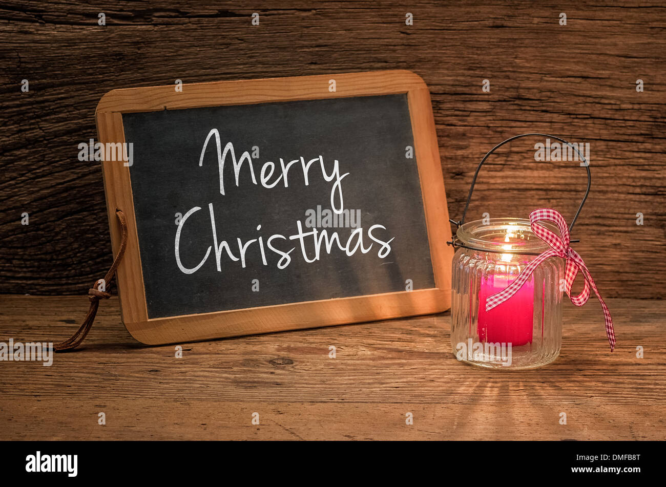 Kerze vor der Tafel mit dem Text Merry Christmas Stockfoto