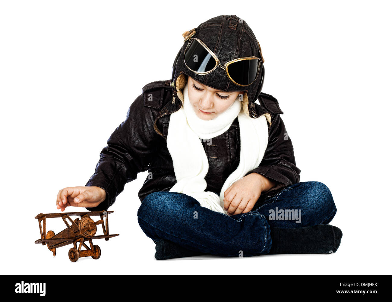 Fröhlicher niedlicher junge gekleidet wie ein zweiter Weltkrieg Pilot spielt mit hölzernen Flugzeug Spielzeug auf weißem Hintergrund. Vintage-look Stockfoto