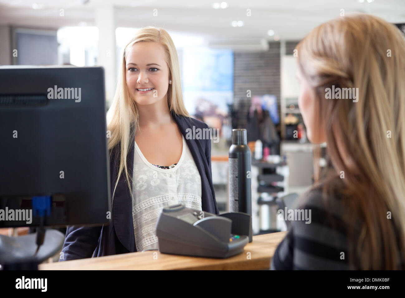 Angestellte an der Rezeption helfen Kunden bei Beauty-Salon Stockfoto