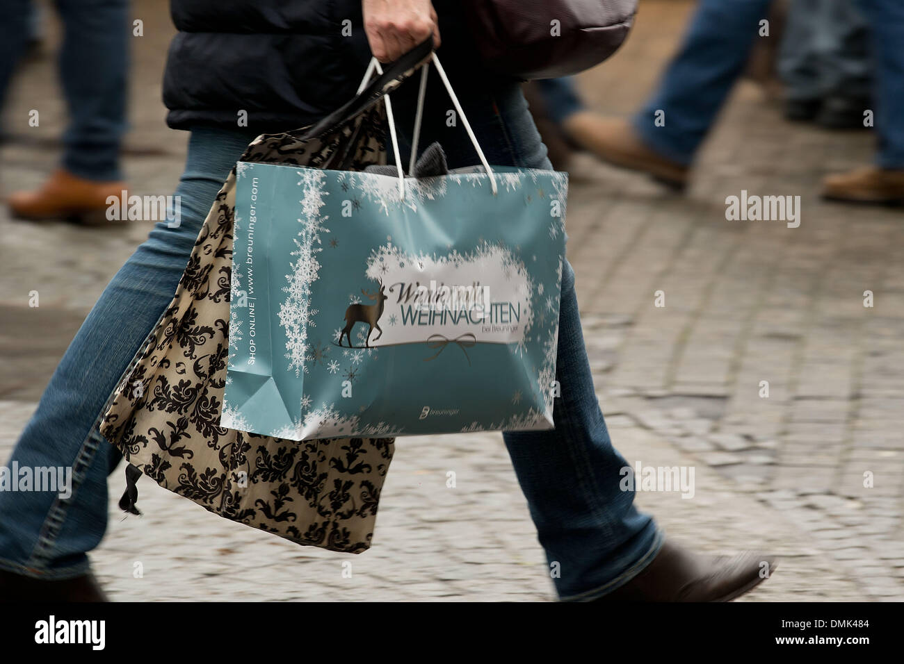 Ein Fußgänger geht mit einer Einkaufstasche durch die Königsstraße in Stuttgart, Deutschland, 14. Dezember 2013. Jedes Jahr Massen von Menschen besuchen die Königsstraße Shop für Weihnachten. Foto: Thomas Niedermueller/dpa Stockfoto