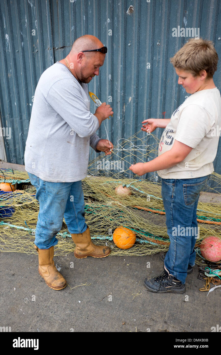 Mann, Sohn beizubringen, Reparatur Fischernetze Flicken Stockfoto