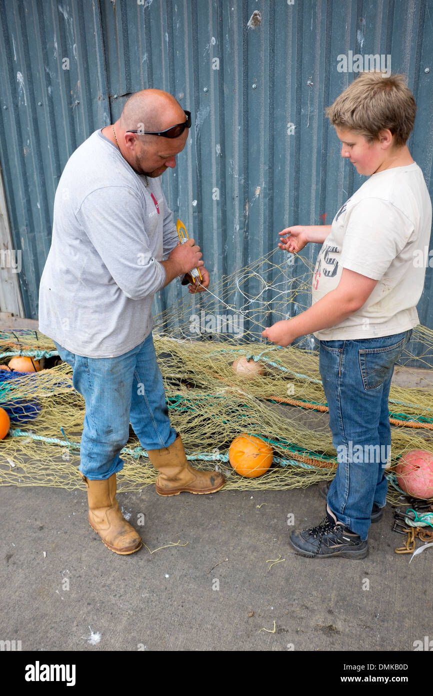 Mann, Sohn beizubringen, Reparatur Fischernetze Flicken Stockfoto