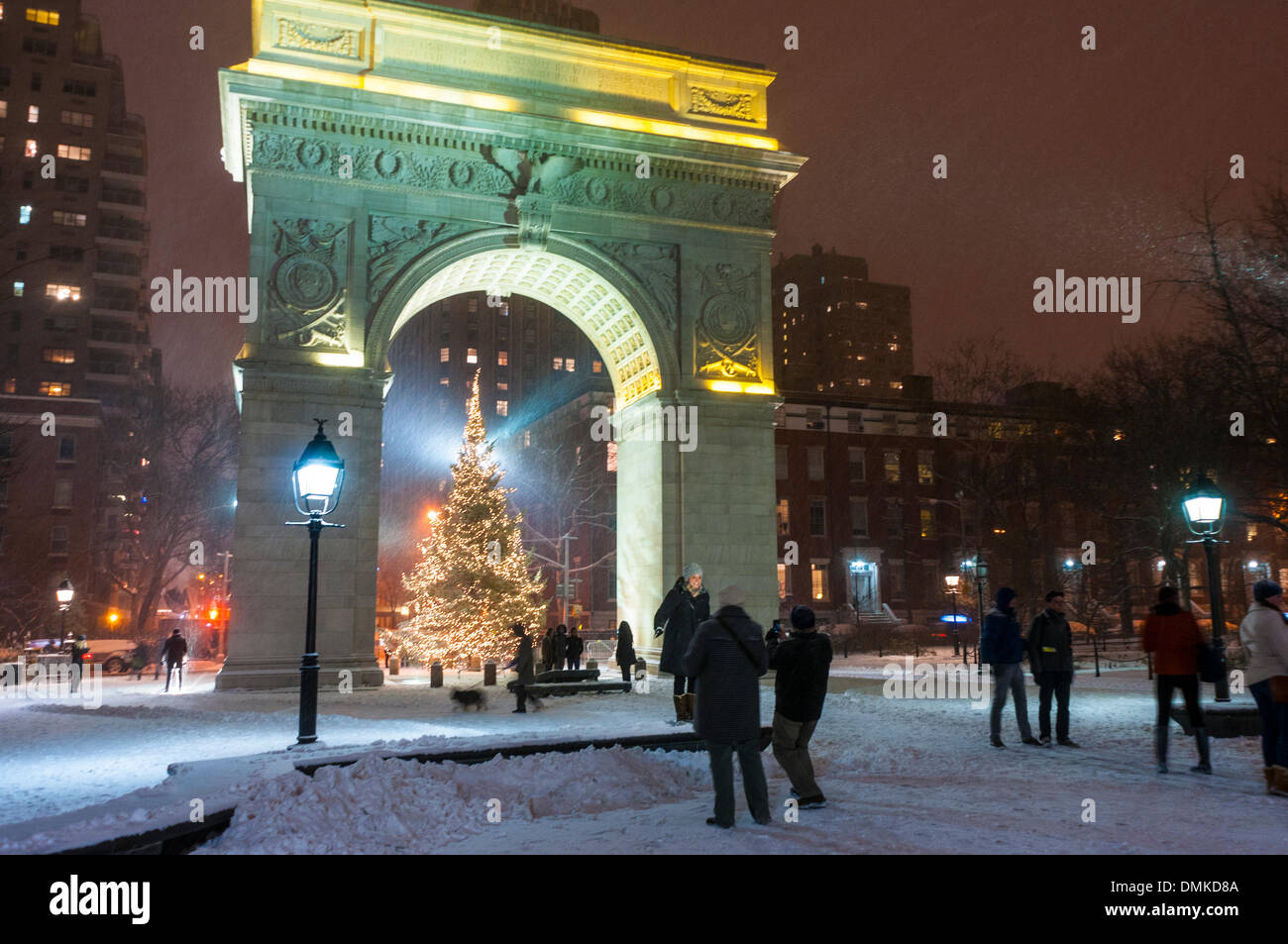 New York, NY 14. Dezember 2013. Touristen posieren für Fotos vor dem Washington Square Arch und Weihnachtsbaum während der ersten Schneesturm der Saison. Der schnelllebigen Sturm, die aus Missouri nach Maine gestreckt, wird voraussichtlich einen Fuß von Schnee oder mehr im Nordosten fallen. Bildnachweis: Stacy Walsh Rosenstock/Alamy Live-Nachrichten Stockfoto