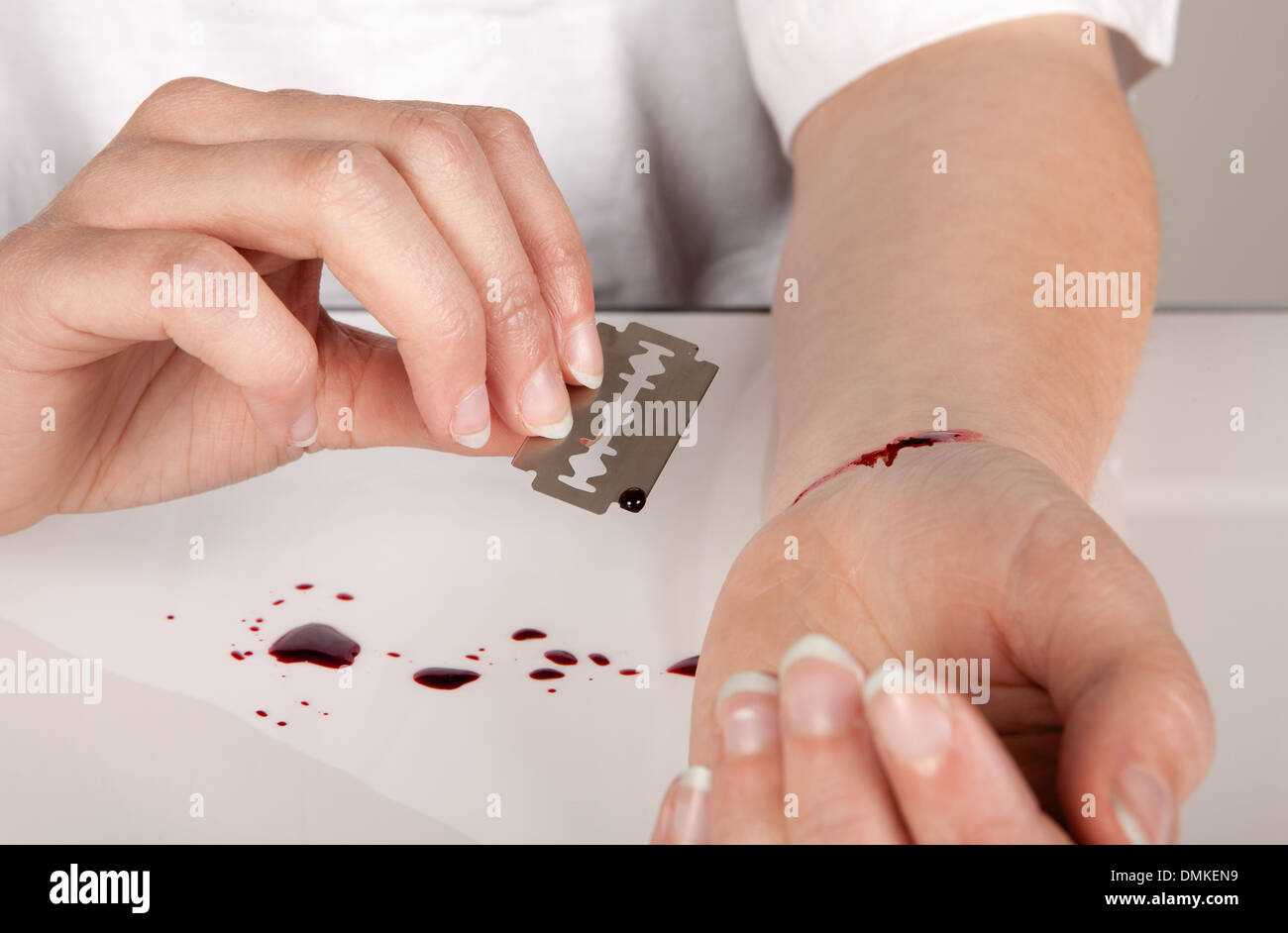 Selbstmordversuch einer Hand mit einer Rasierklinge Stockfoto