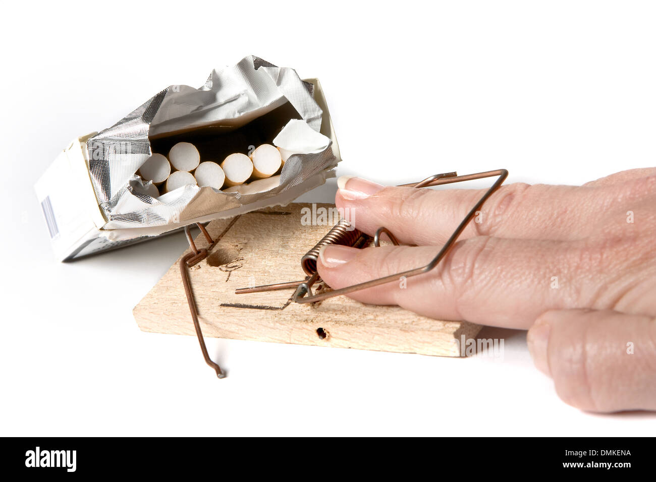 Hand bei dem Versuch, eine Zigarette nehmen in einer Mausefalle gefangen Stockfoto