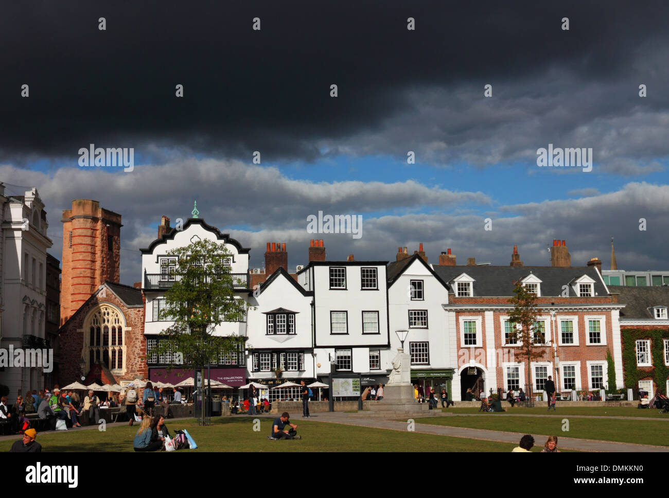 Eine Kirche aus rotem Sandstein und Fachwerkbauten gegen einen pechschwarzen schwarzen Himmel. Stockfoto