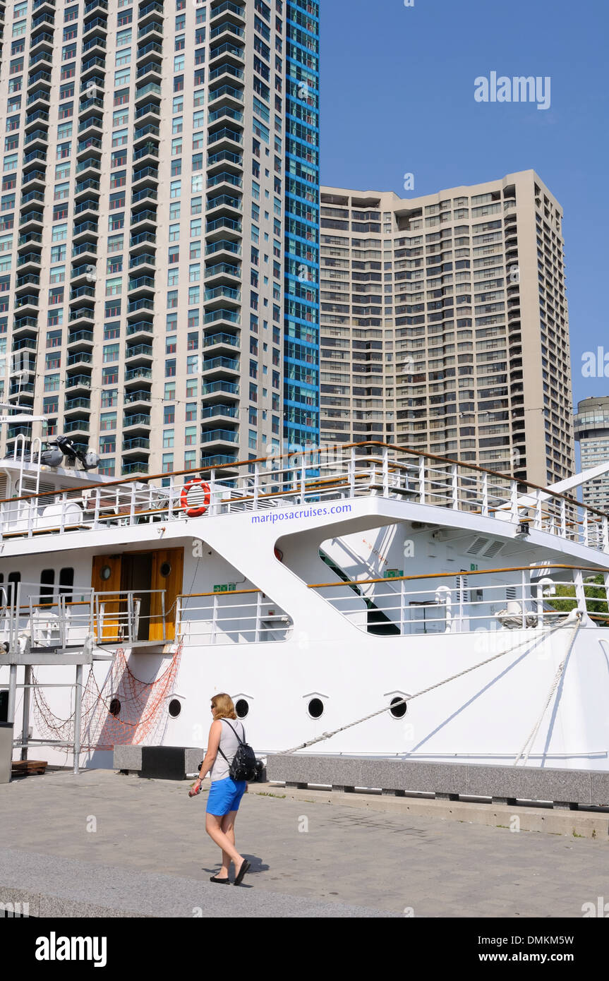 Ein Mariposa Kreuzfahrtschiff in den Schatten gestellt durch die umliegenden Wolkenkratzer im Hafen von Toronto, Ontario, Kanada Stockfoto