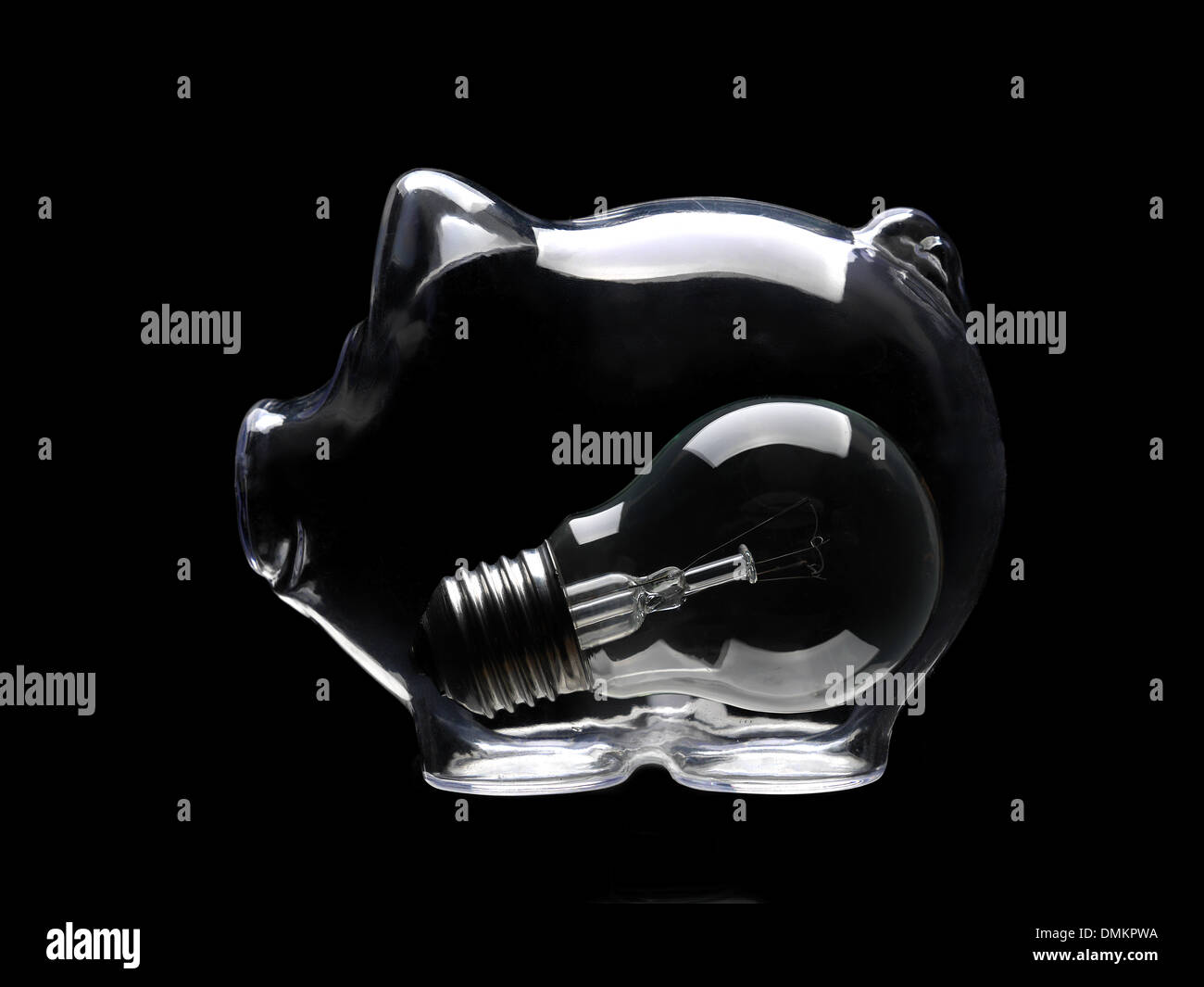 Konzeptionelle Schuss der Glühbirne in Glas Sparschwein auf schwarzem Hintergrund platziert Stockfoto