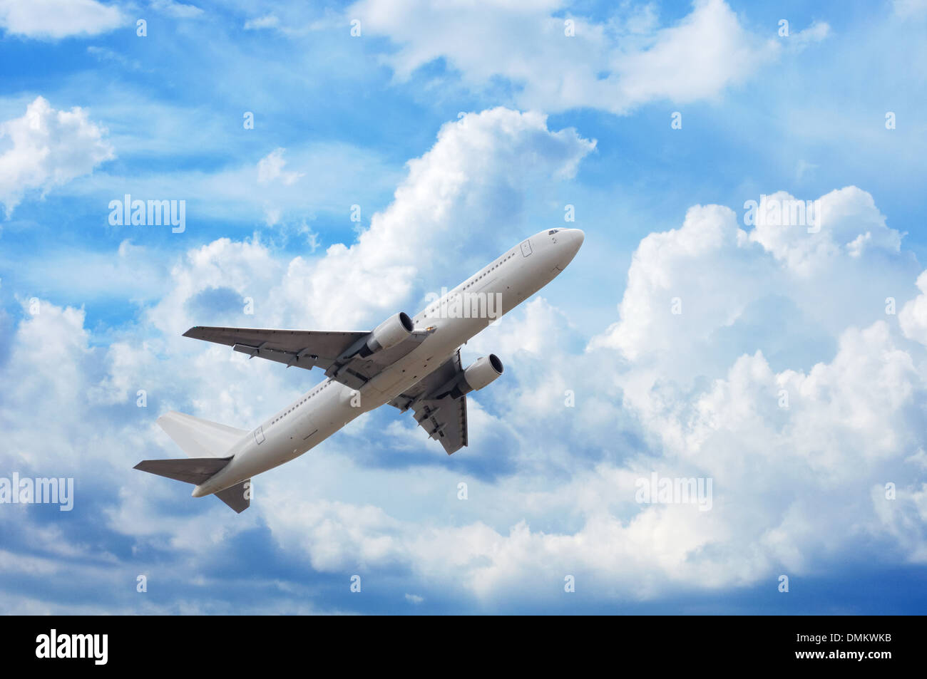 Flugzeug in den Himmel voller flauschige Wolken Stockfoto