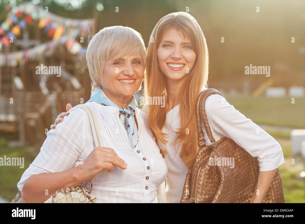 Mutter mit ihrer Tochter schaut in die Kamera im Garten Stockfoto