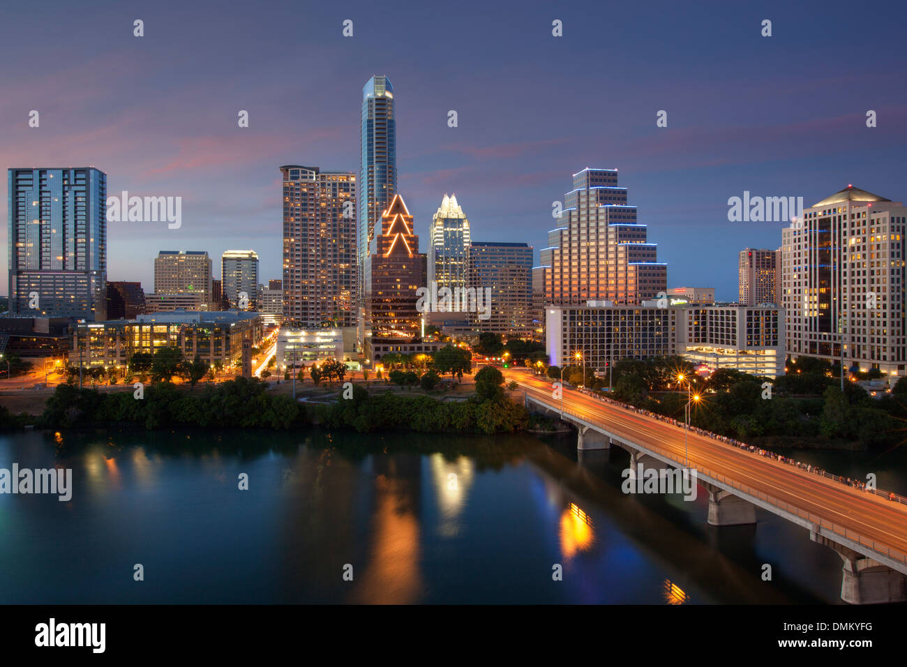 Die Skyline von Austin am Abend erstrahlt im Abendlicht. Die Reflexionen der Hochhäuser spiegeln sich im Wasser. Stockfoto