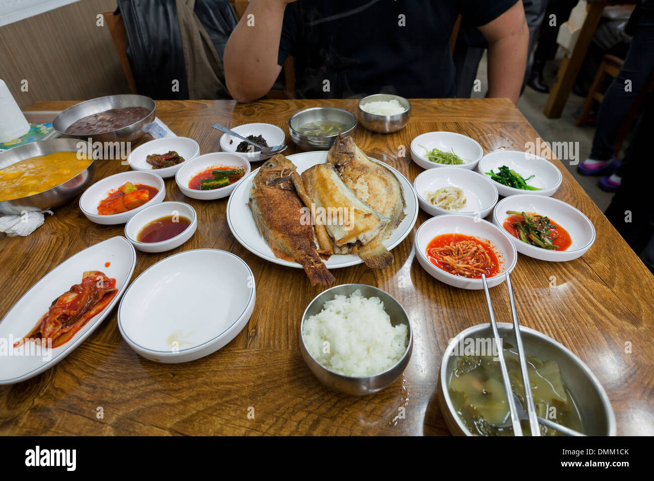 Koreanische gebratenen Fisch-Mahlzeit und Beilagen am Tisch - Südkorea Stockfoto