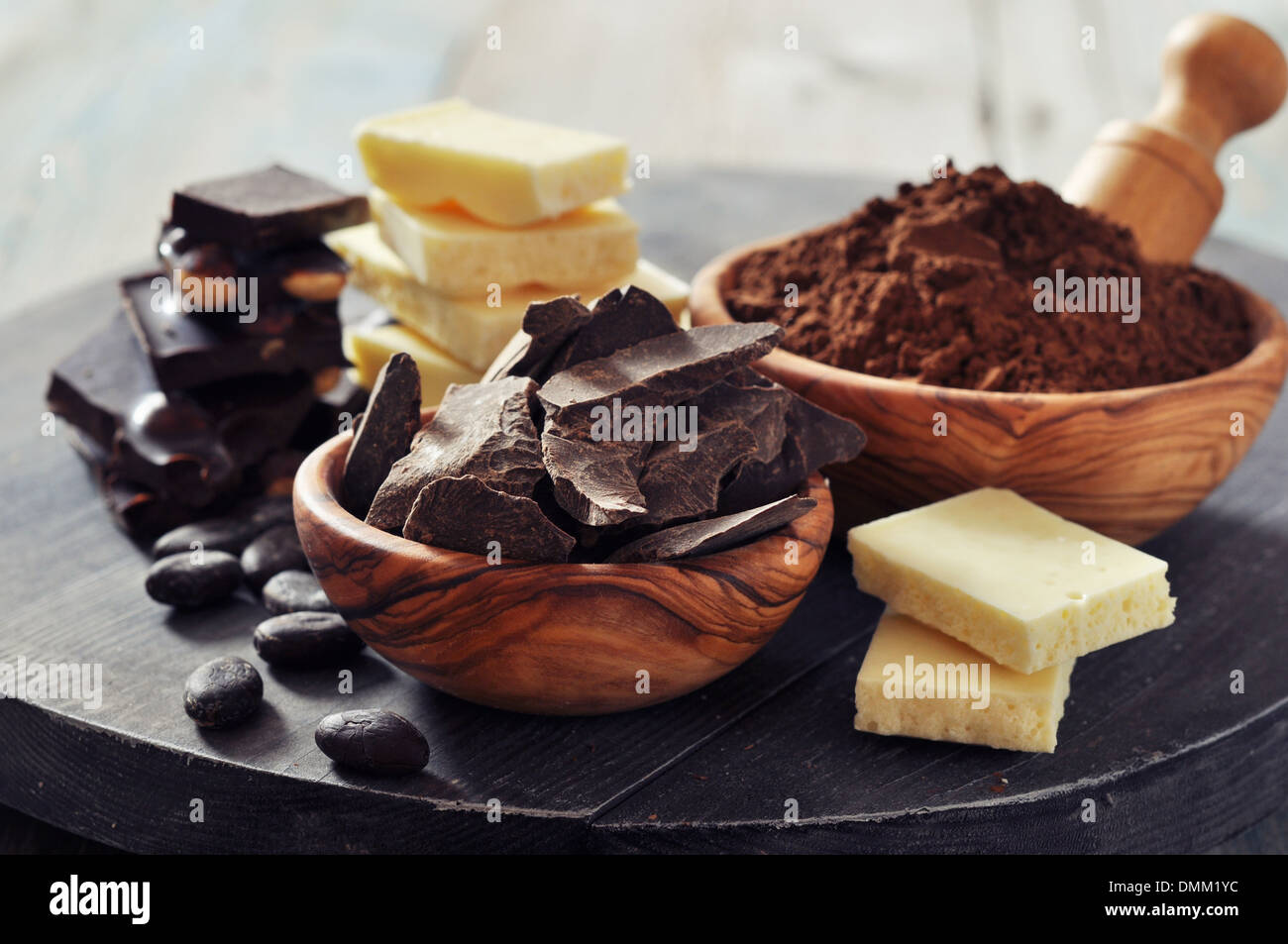Schokoladenstücke mit Kakaobohnen und Kakaopulver auf hölzernen Hintergrund Stockfoto