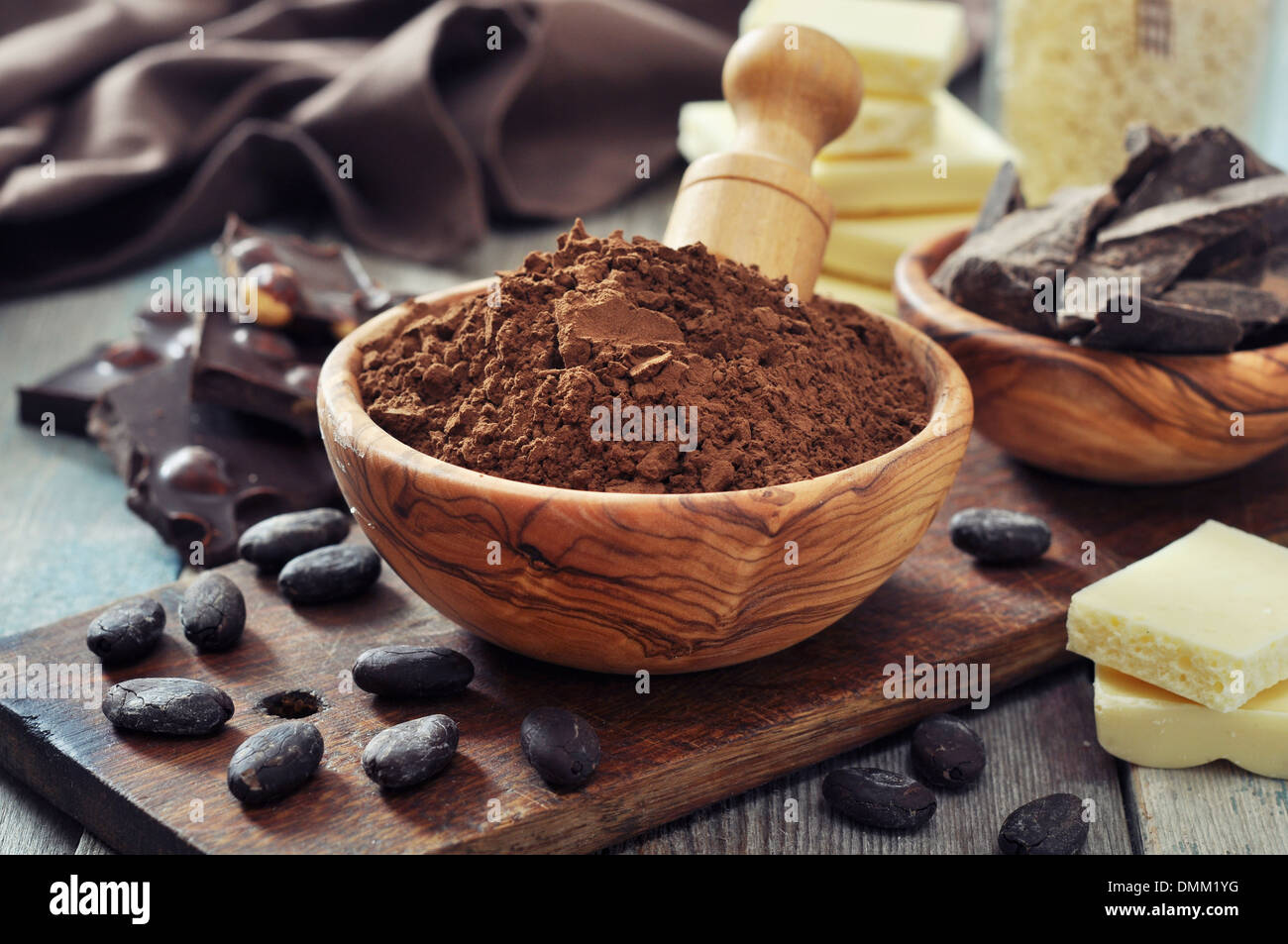 Schokoladenstücke mit Kakaobohnen und Kakaopulver auf hölzernen Hintergrund Stockfoto
