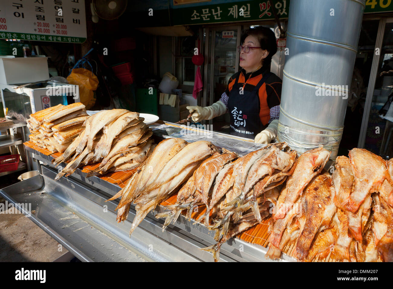 Frau braten frische ganze Fische am Jagalchi Shijang (traditionelle outdoor-Markt) - Busan, Südkorea Stockfoto