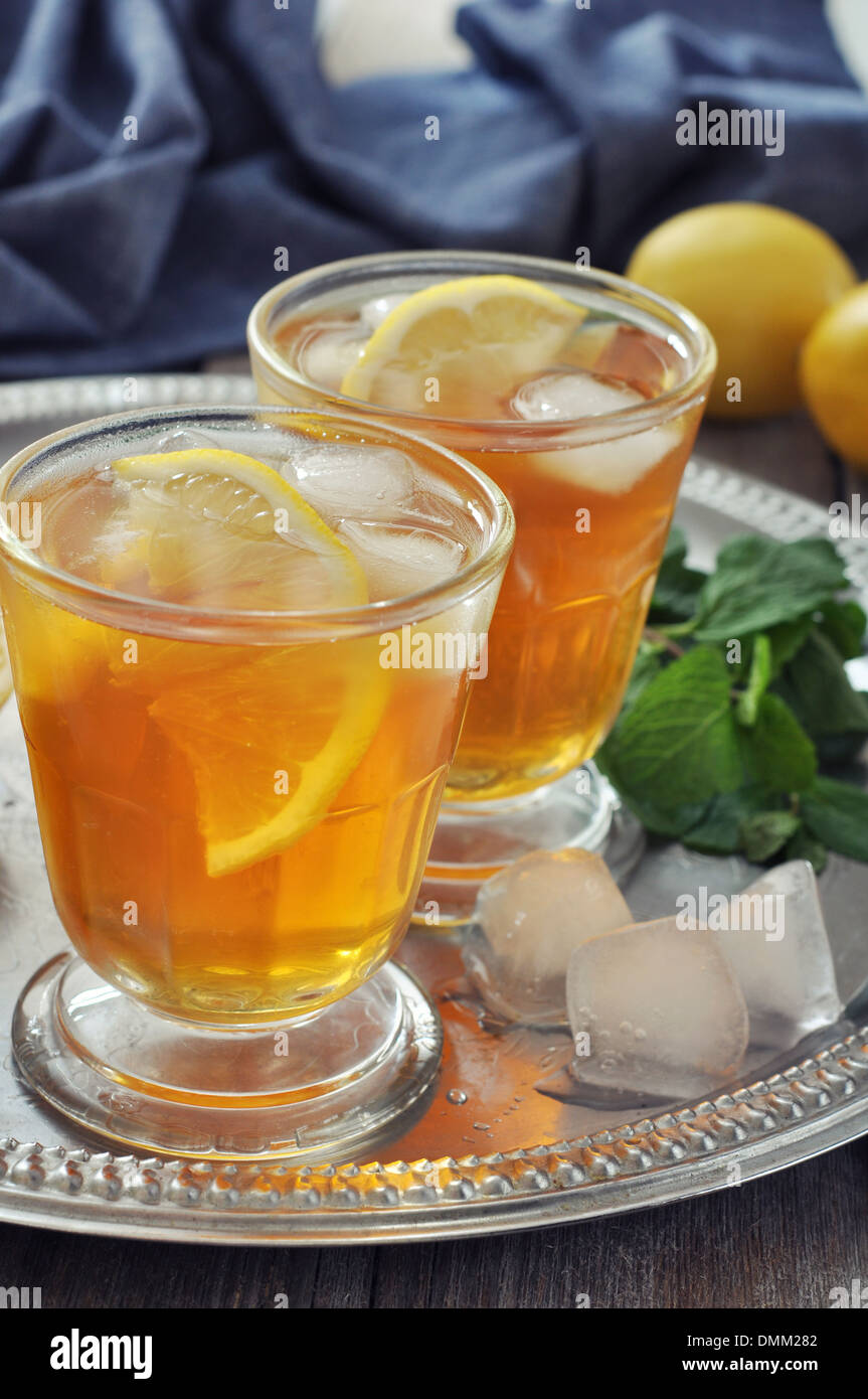 Eistee in Glas mit Zitrone und Minze auf Metalltablett Stockfoto