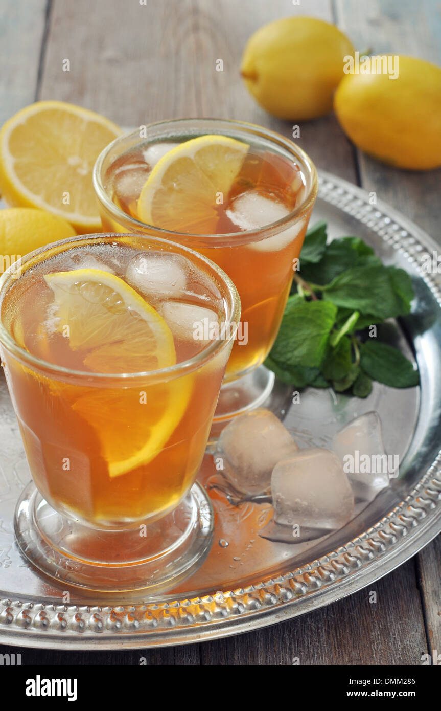 Eistee in Glas mit Zitrone und Minze auf Metalltablett Stockfoto