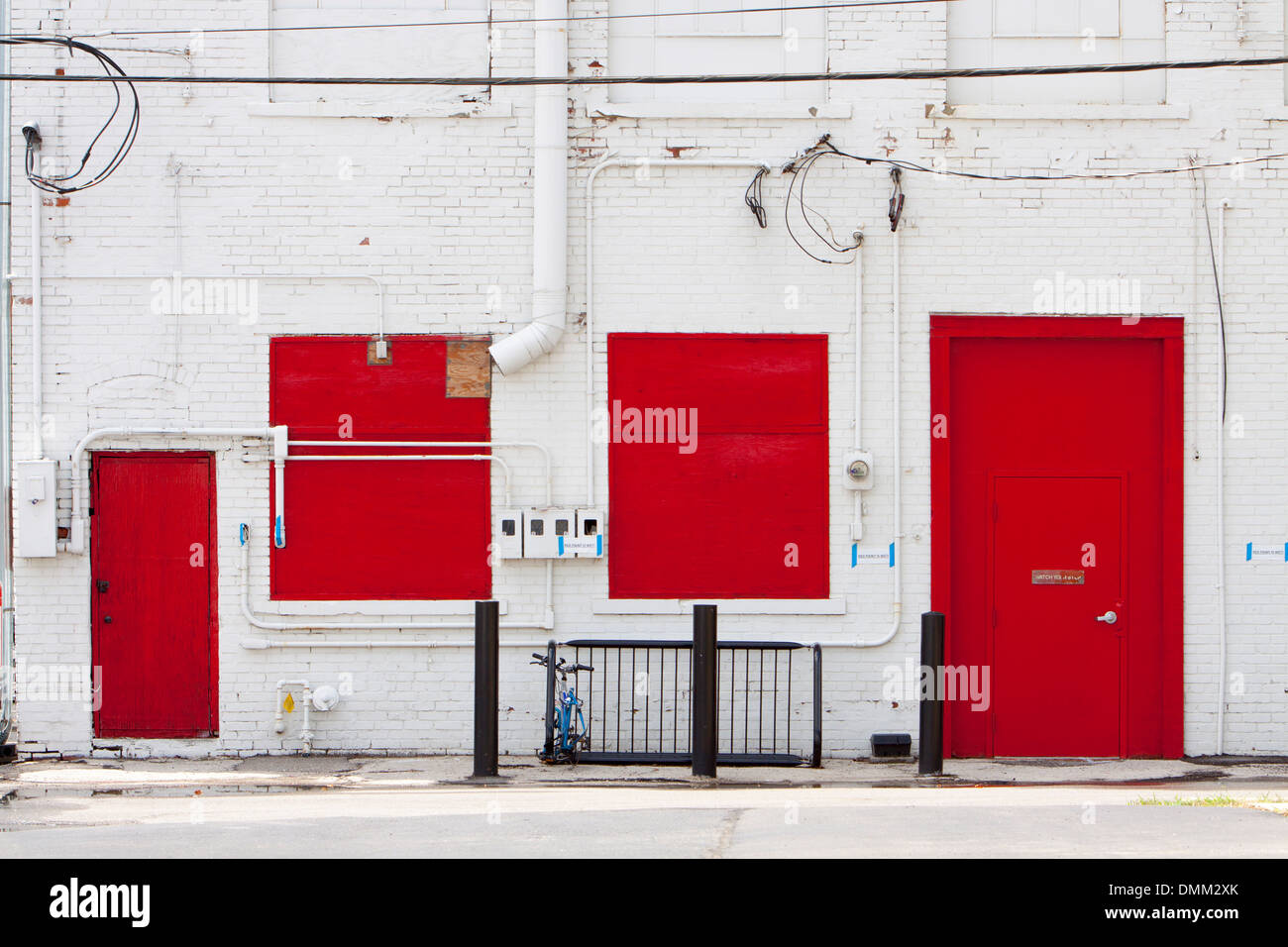 Rote Türen und Fenster auf der Rückseite ein weißes Gebäude in Columbus, Ohio, USA. Stockfoto