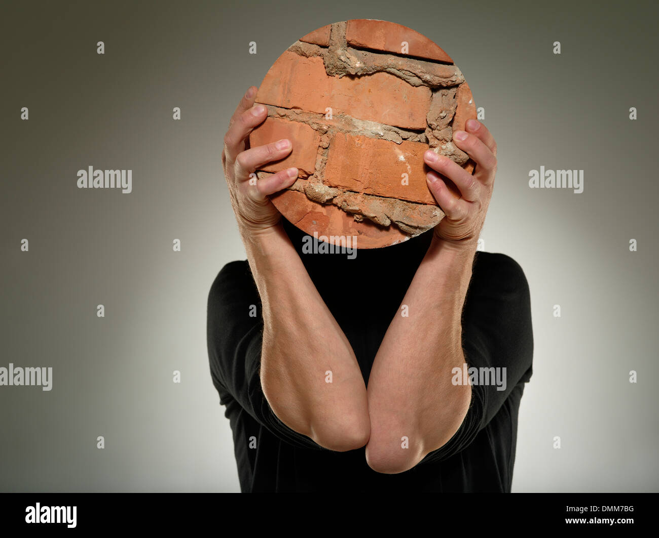 Mann halten am Stück abgerundeten Mauer über sein Gesicht. Obsession-Konzept. Stockfoto