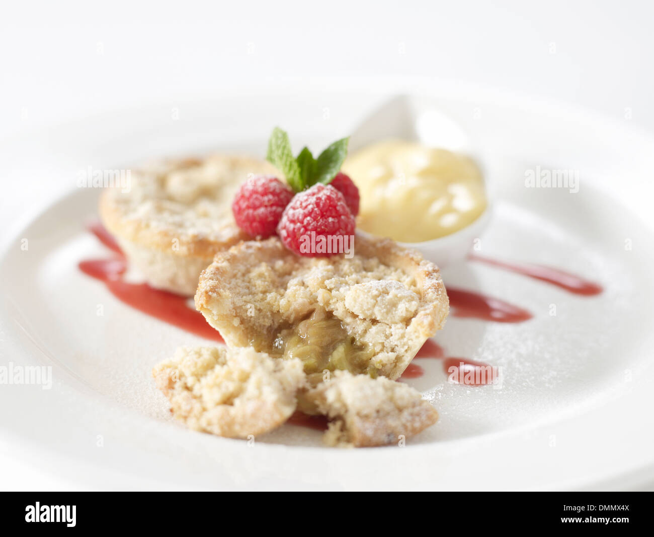 Apfel Rhabarber Torte Himbeeren Erdbeersauce Creme in einem Topf auf der Seite Stockfoto